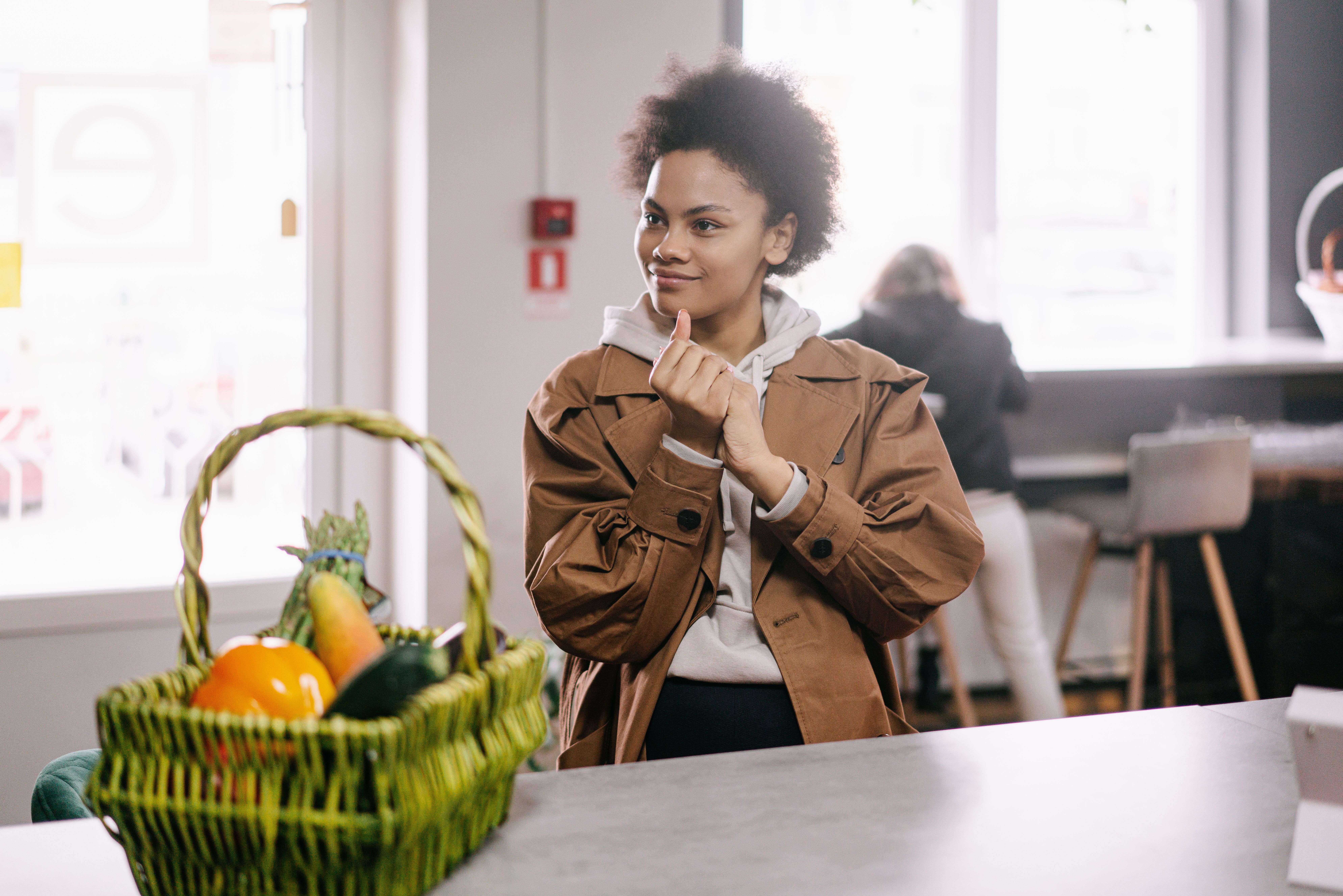 Woman receiving a bag of groceries from another woman
