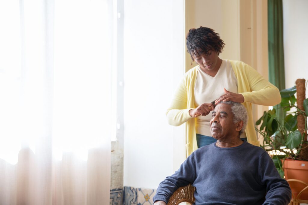 Woman brushing an older woman’s hair at home