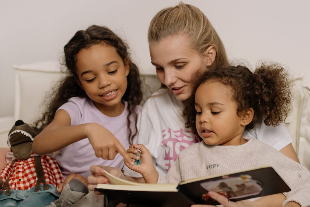 Woman reading a book with two children